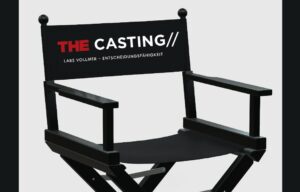 Black director's chair with a backrest banner reading THE CASTING in red and white, used for film auditions.