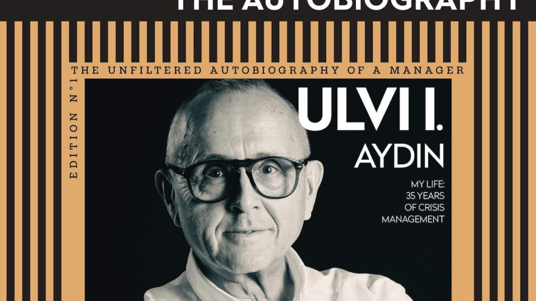 Book cover for Ulvi Aydın's autobiography, portrait of the author wearing glasses with an orange striped frame and bold title.