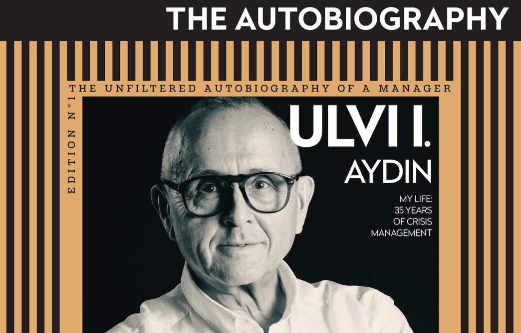 Book cover for Ulvi Aydın's autobiography, portrait of the author wearing glasses with an orange striped frame and bold title.