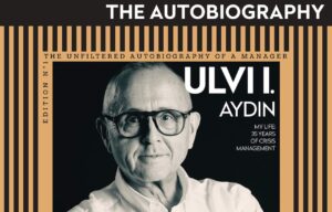 Book cover for Ulvi Aydın's autobiography, portrait of the author wearing glasses with an orange striped frame and bold title.