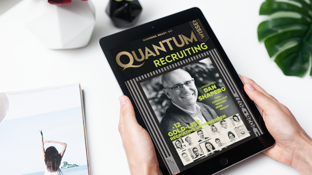Tablet held by hands showing a magazine cover titled 'Quantum Recruiting' on screen with a photo of a man and recruitment headlines (Dan Shapiro)